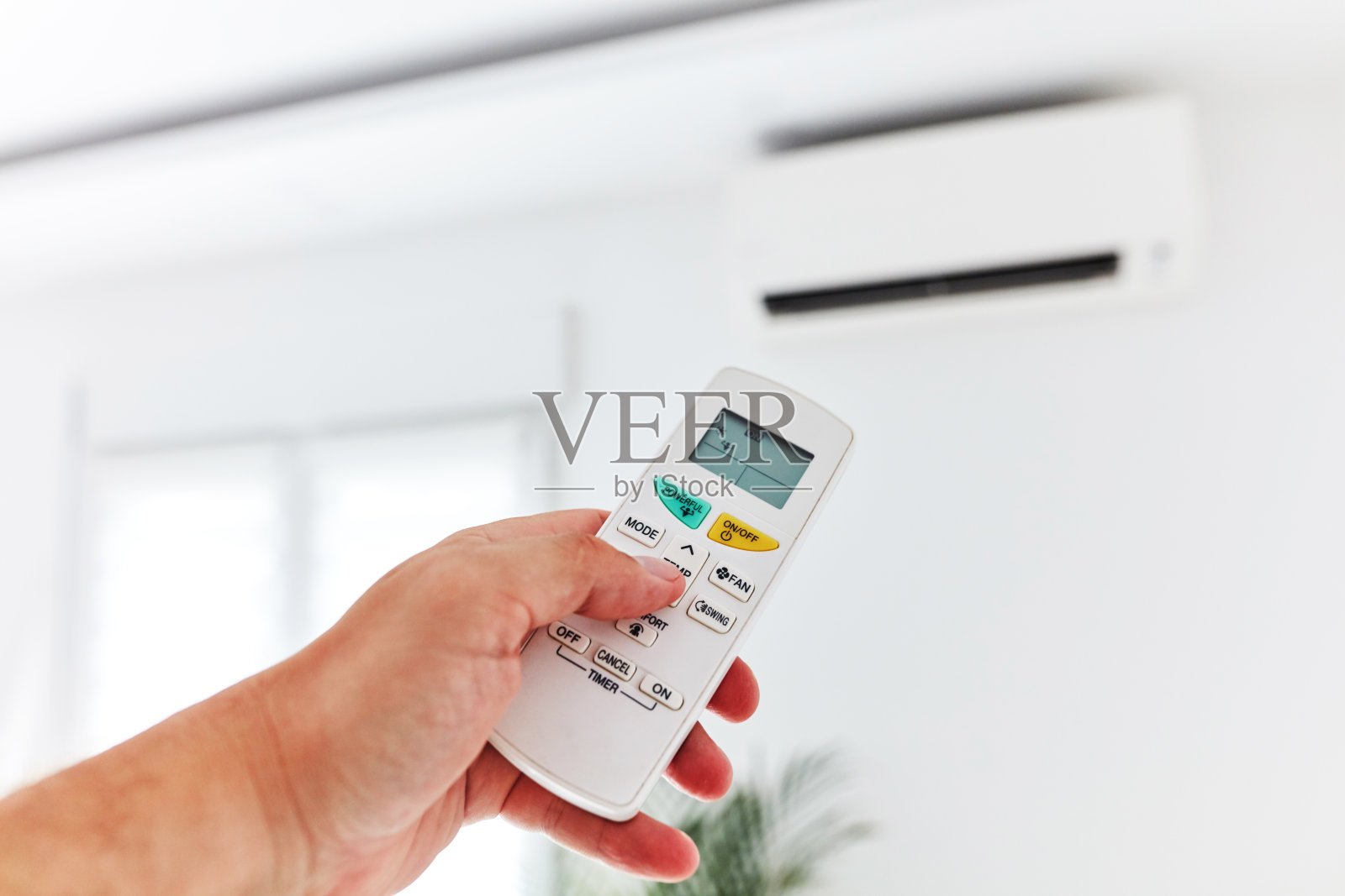 一款手持遥控器的现代空调。照片摄影图片