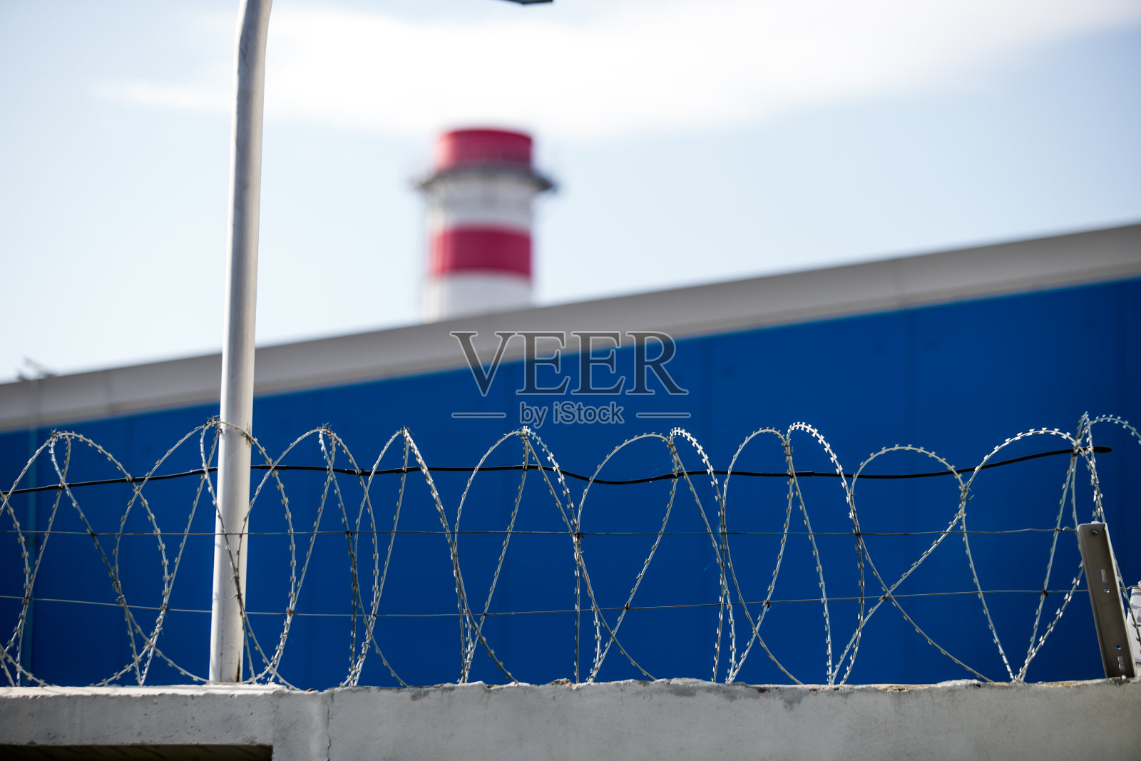 监狱高墙周围的铁丝网，背景是蓝天照片摄影图片