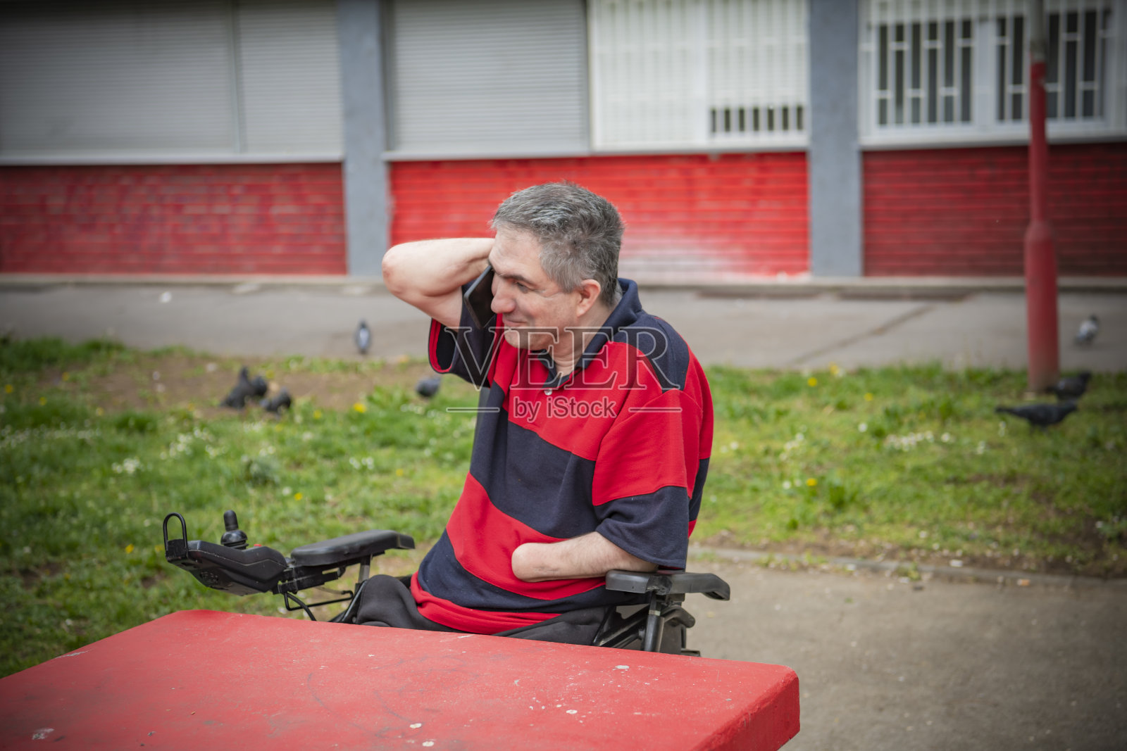 一个没有手的残疾人在打电话照片摄影图片