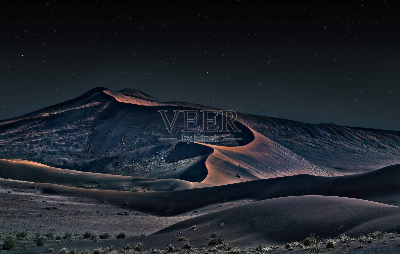 夜间的纳米布沙漠，橙色的沙丘和星空照片摄影图片