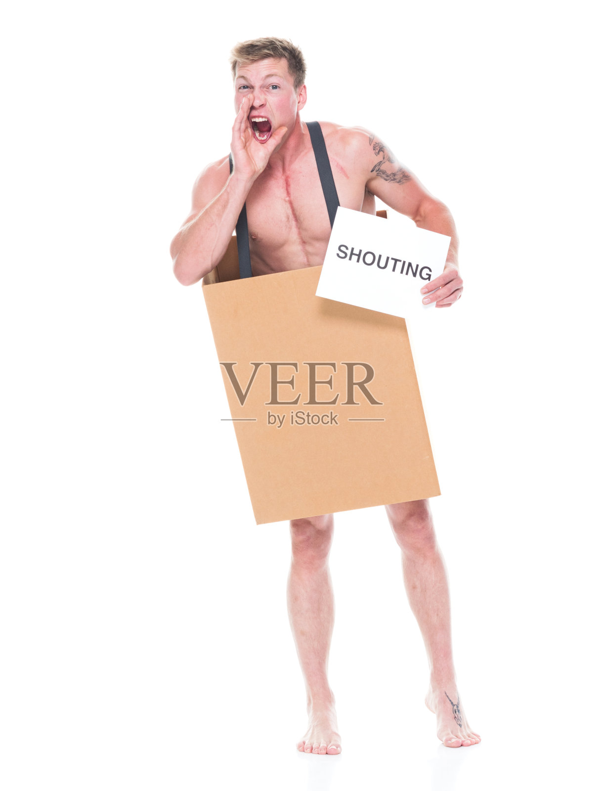 正面图片/全身/一个20-29岁的白人男性/年轻男子站在白色背景前，穿着背带，绝望/饥饿/贫穷/赤裸上身/大喊/尖叫/不高兴/侵略/愤怒照片摄影图片