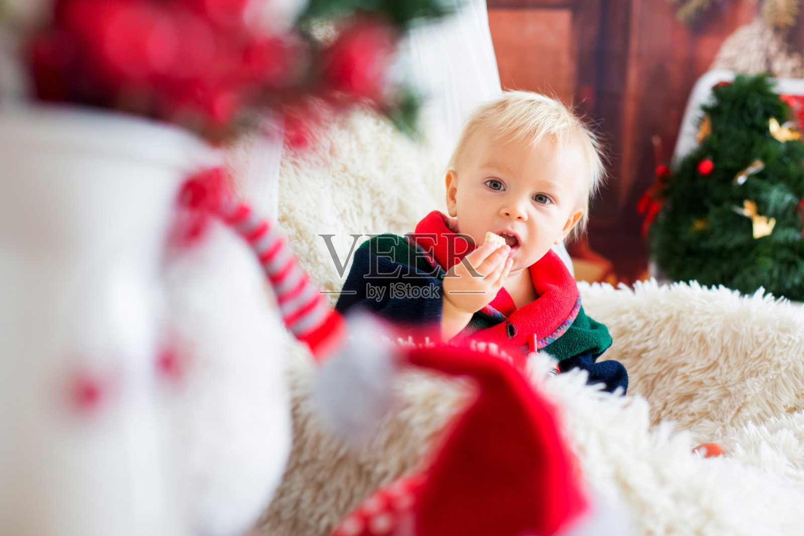 圣诞节男婴，穿圣诞老人袍坐摇椅照片摄影图片