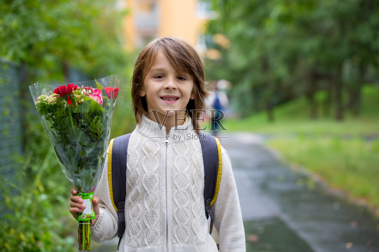快乐的学校小朋友，手捧花束，第一天上学照片摄影图片