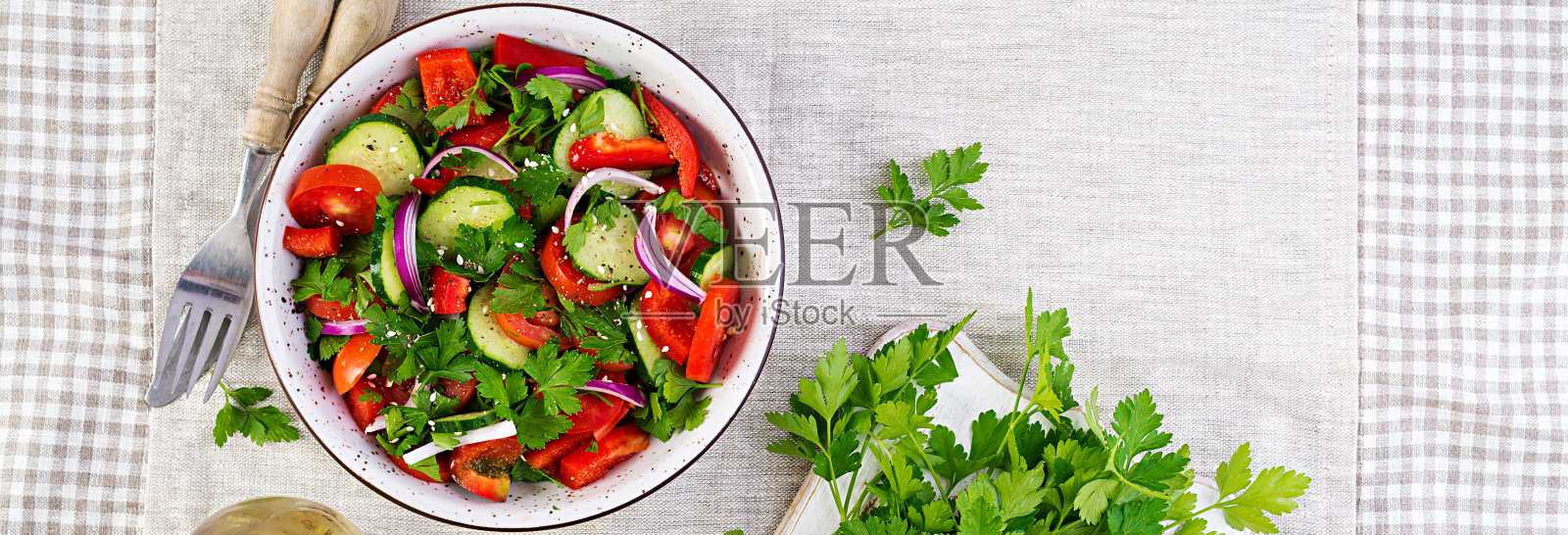 番茄黄瓜沙拉配红洋葱，红辣椒，黑胡椒和欧芹。素食食物。饮食菜单。前视图。平躺照片摄影图片