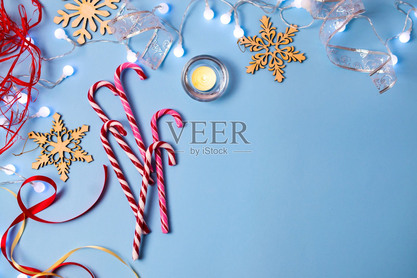圣诞装饰元素在蓝色的背景，糖果手杖，蜡烛，雪花和丝带照片摄影图片