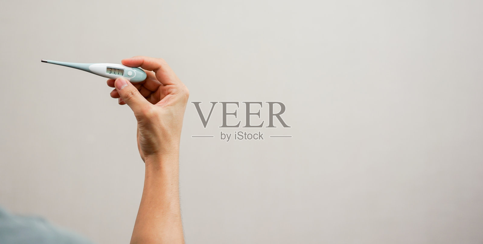 近距离观察年轻男子手拿数字体温计在卧室看体温设备为发烧和寒冷不健康的生活理念照片摄影图片