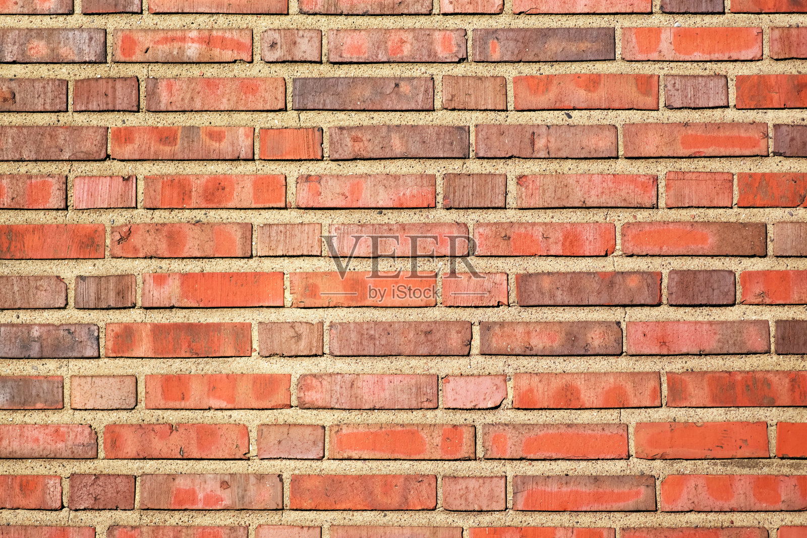 红砖背景上涂着厚厚的一层水泥，是一堵砖墙的碎片。施工期间的纹理、墙面覆层照片摄影图片