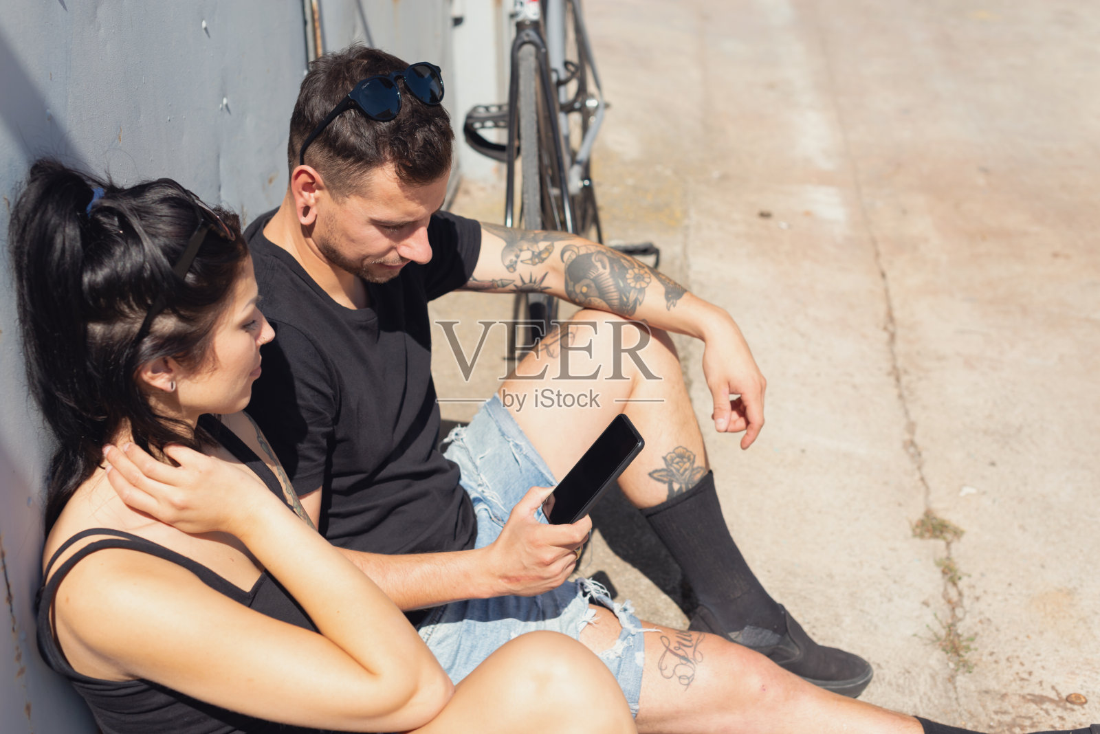 纹身夫妇查看手机照片摄影图片