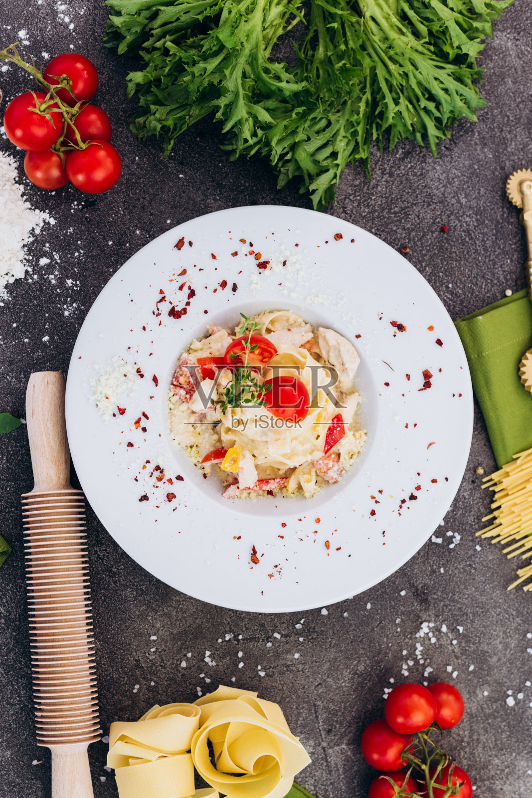 用意大利面条做成的意大利面，在灰色的背景上用装饰来宣传菜单。照片摄影图片
