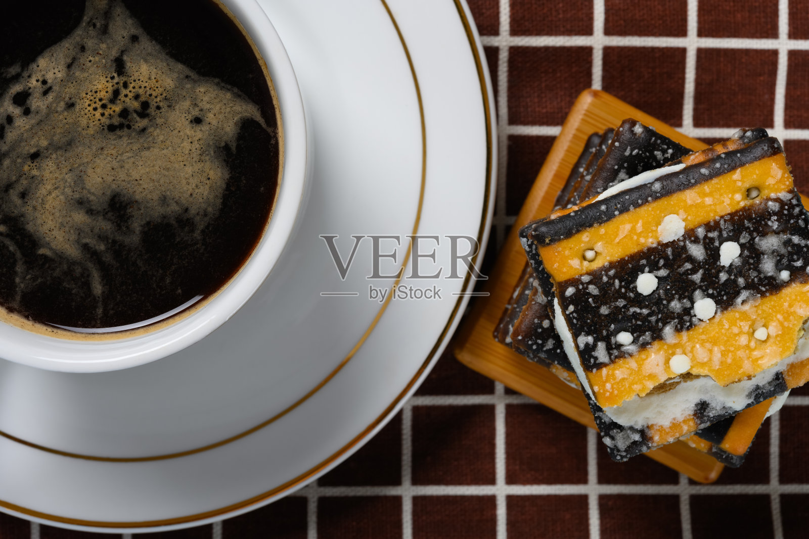 俯视图一杯咖啡和一堆夹心白奶油的三明治饼干照片摄影图片