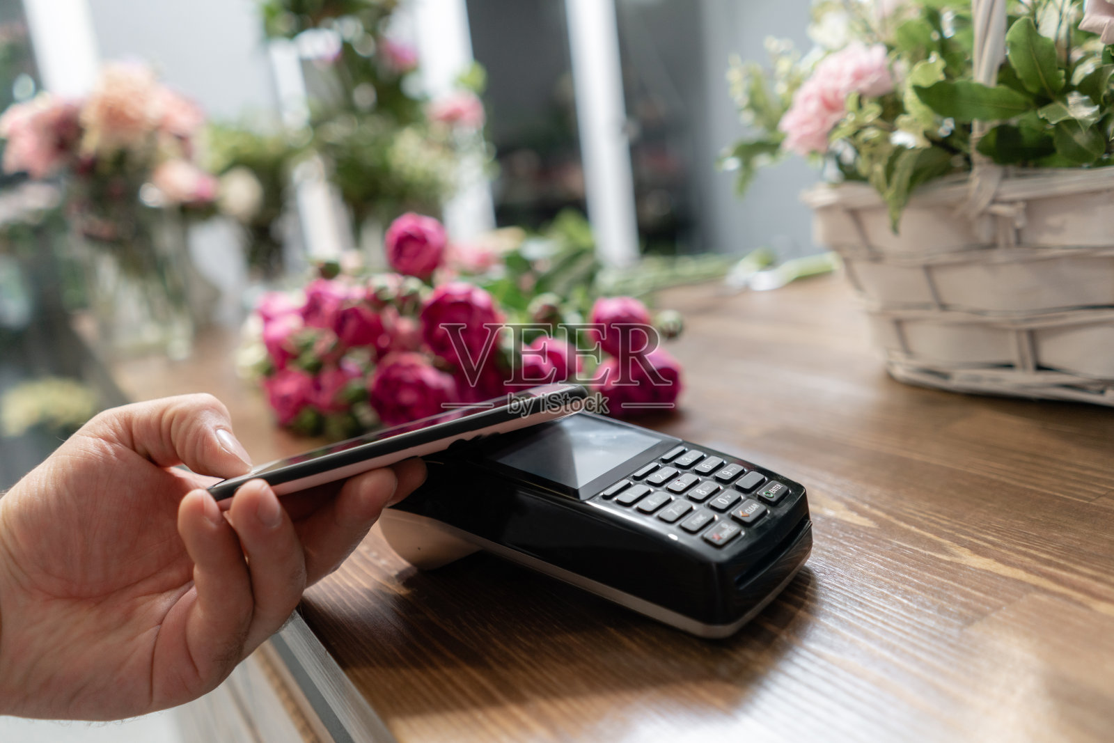 非接触式支付概念。使用智能手机、pos机、打印支票进行支付。花店概念。鲜花交付照片摄影图片