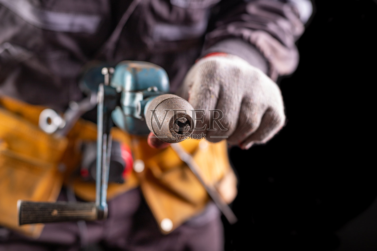 生产工人带工具带。在员工手中操练。黑暗的背景。照片摄影图片