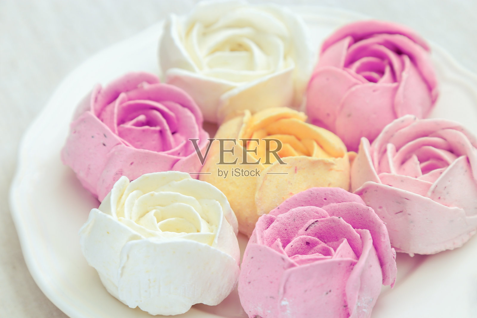 白色的盘子里放着混合了各种糖果的甜棉花糖。由天然产品制成的甜点。健美的形象。有选择性的重点。照片摄影图片