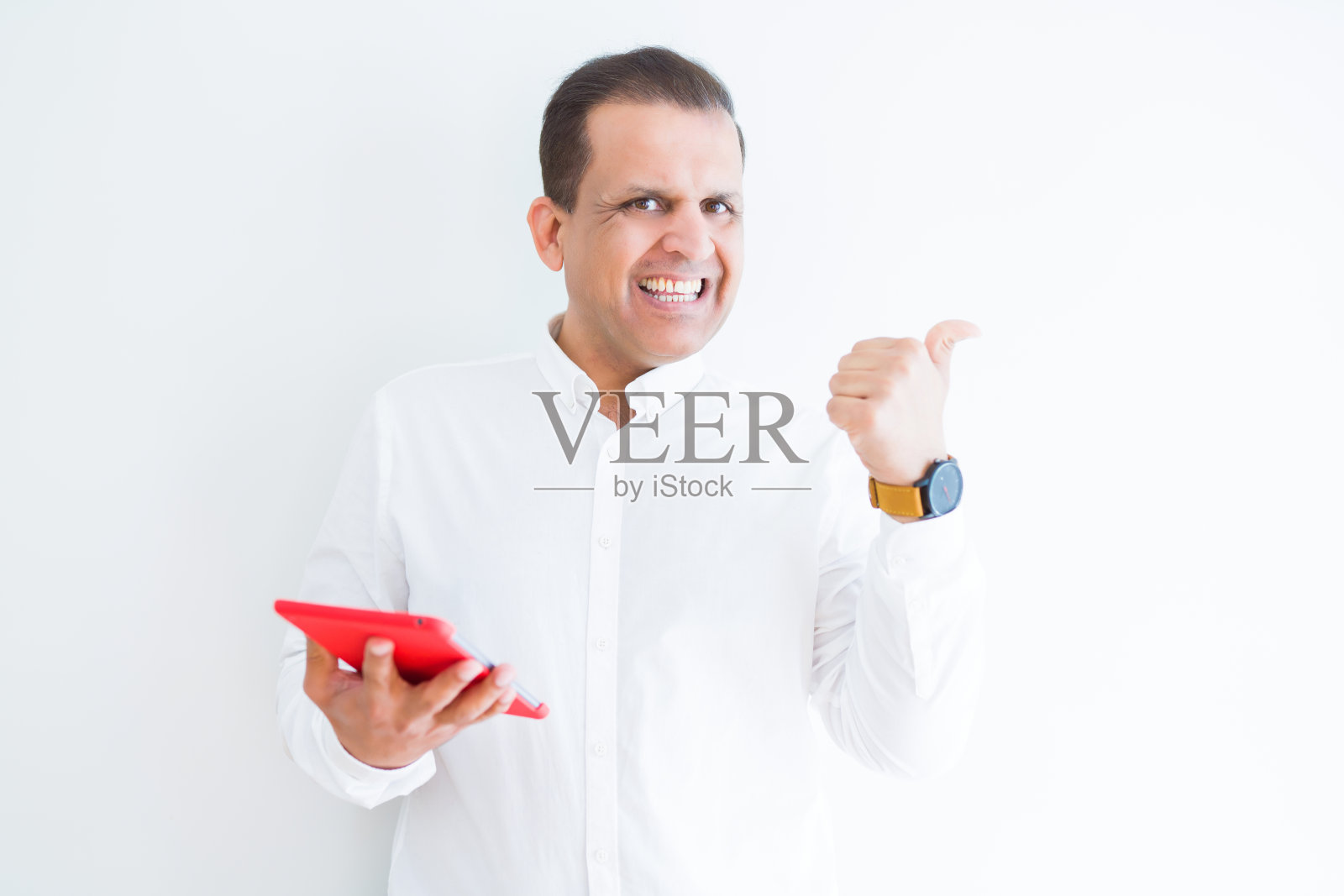 中年男子使用数字桌子在白色墙壁指向和显示与拇指向上的一边与快乐的脸微笑照片摄影图片