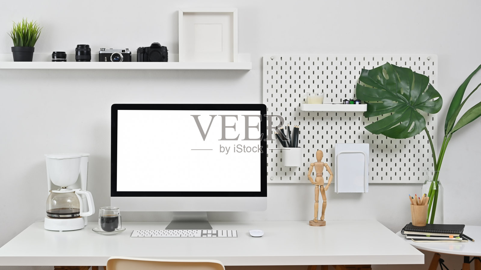 桌子上放着电脑、相机、镜头和咖啡机。照片摄影图片