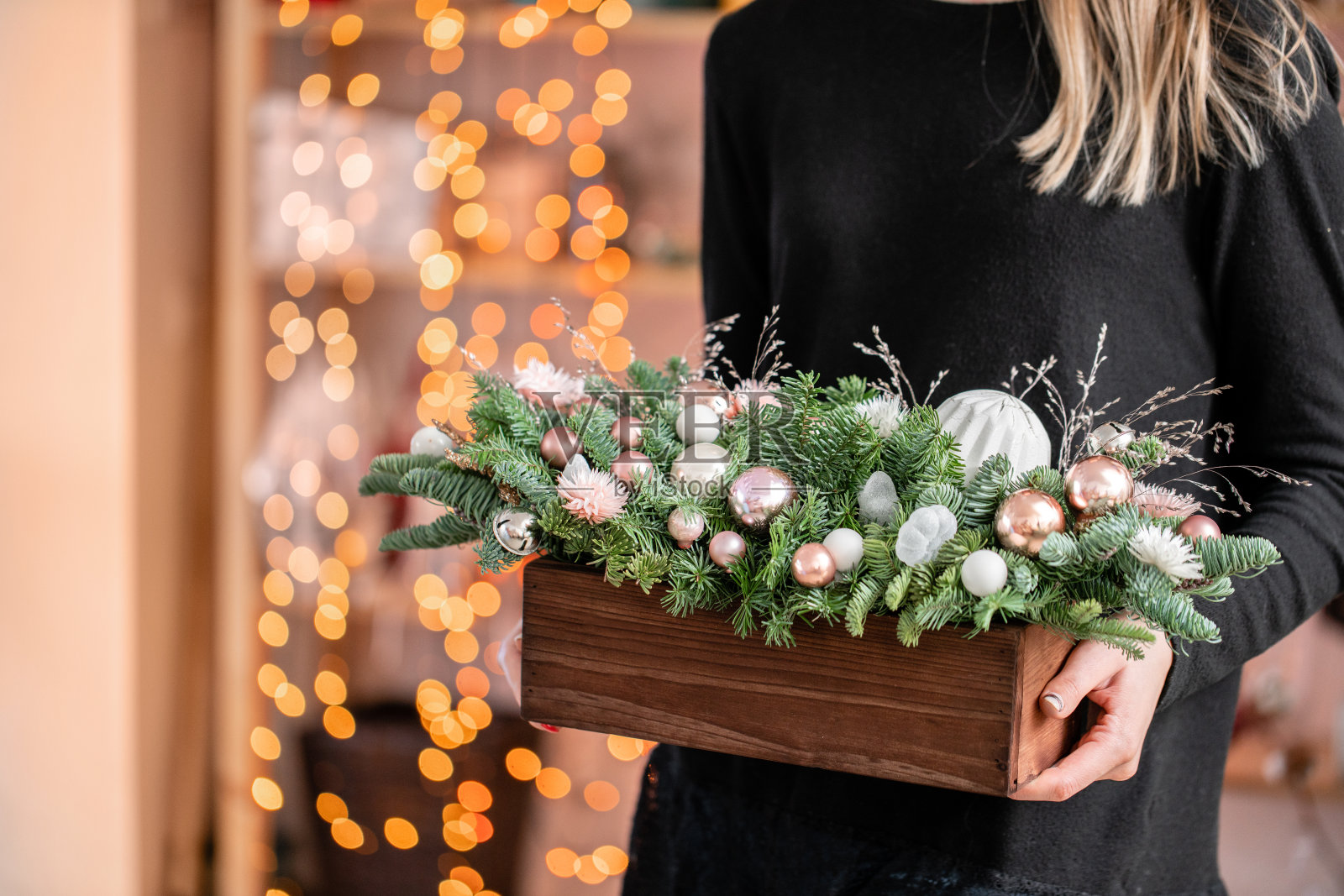 美丽的节日安排新鲜云杉，粉红色的装饰品在一个乡村的木箱。圣诞节的心情。Garland bokeh背景。背景是花环灯的散景。照片摄影图片