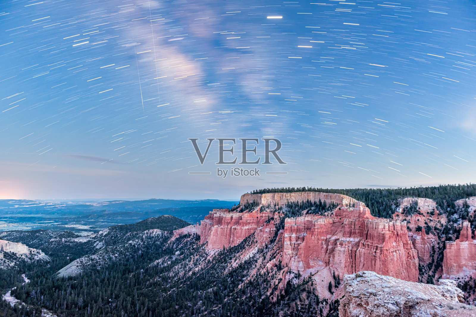 在美国犹他州的布莱斯峡谷国家公园，夜空中星星的轨迹显示出红色的峡谷景观，银河和蓝色的帕里亚视图照片摄影图片