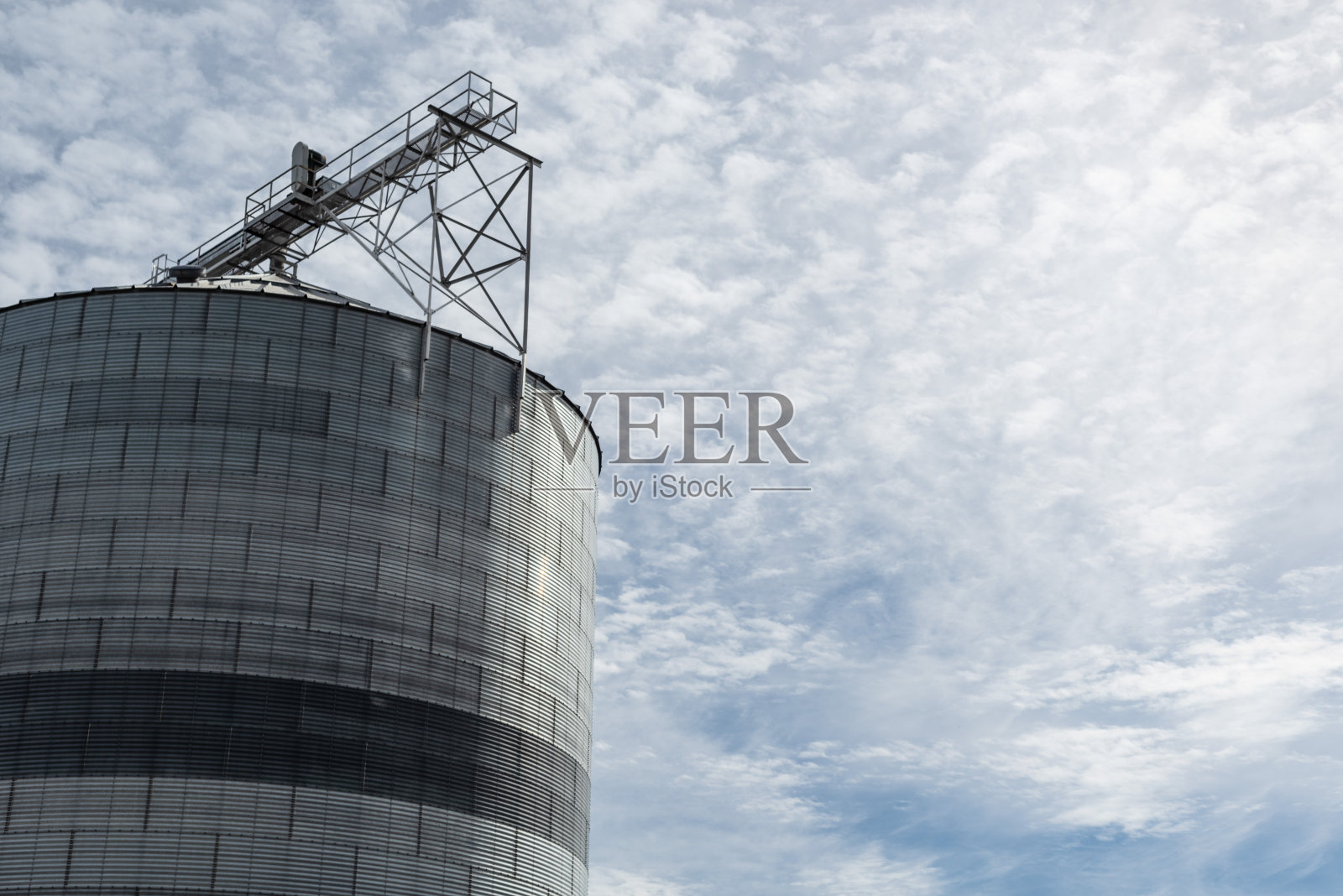 抬头看着一个金属筒仓。包括负空间。照片摄影图片