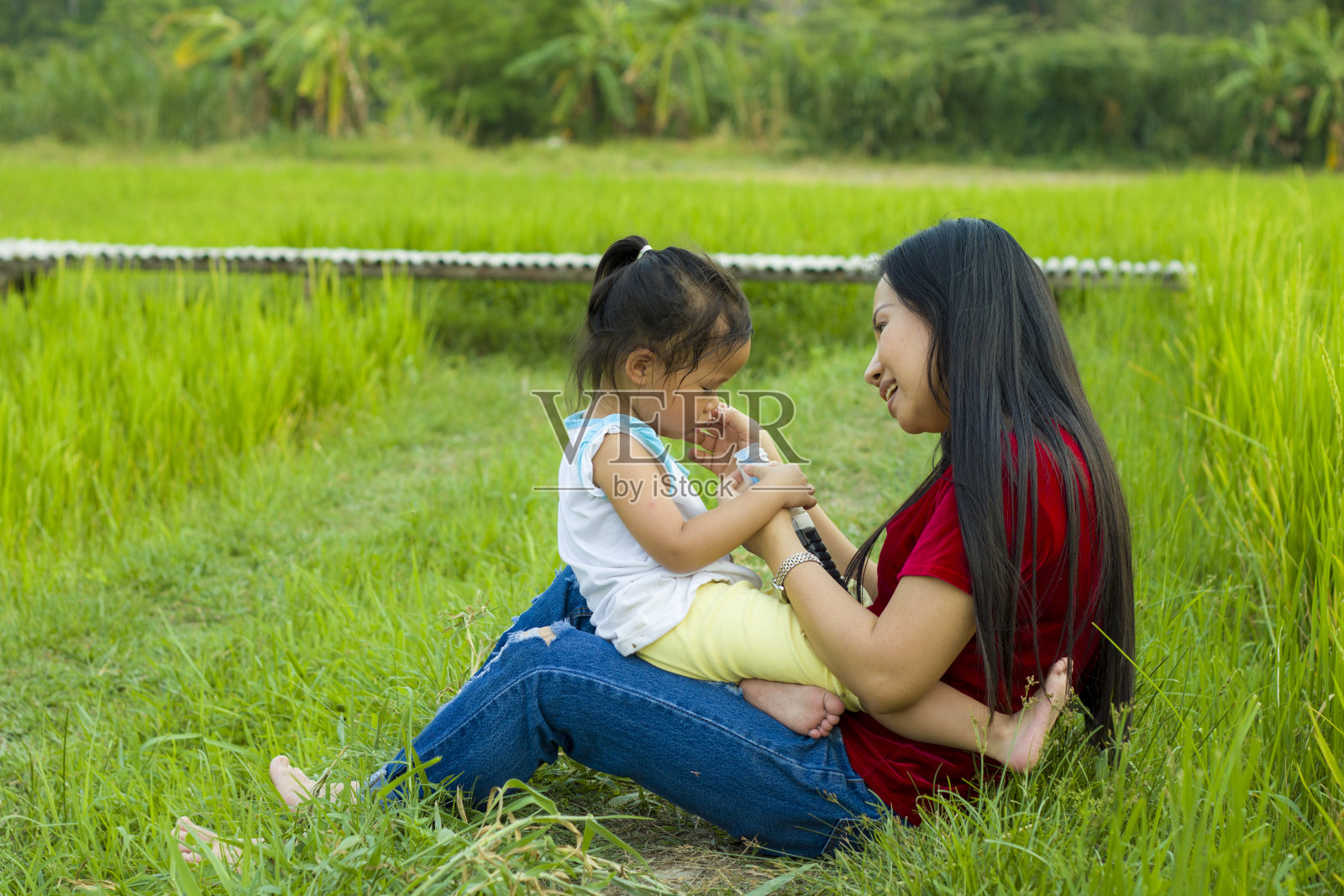 生活方式肖像母亲和女儿在幸福在外面的草地，有趣的亚洲家庭在稻田。照片摄影图片