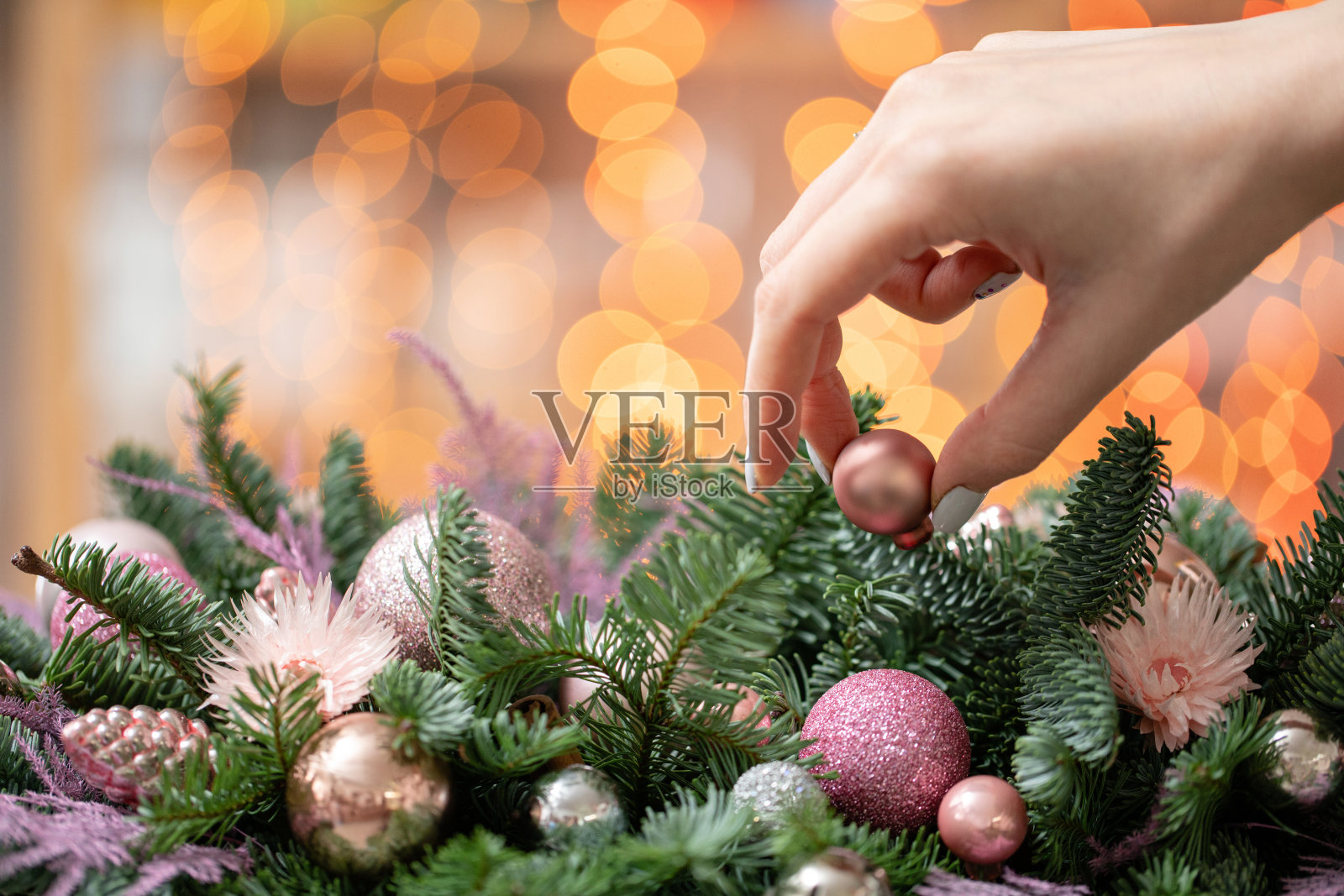 年轻女子创造和装饰美丽的节日安排新鲜云杉，装饰在一个乡村的木制盒子。圣诞节的心情。Garland bokeh背景。照片摄影图片