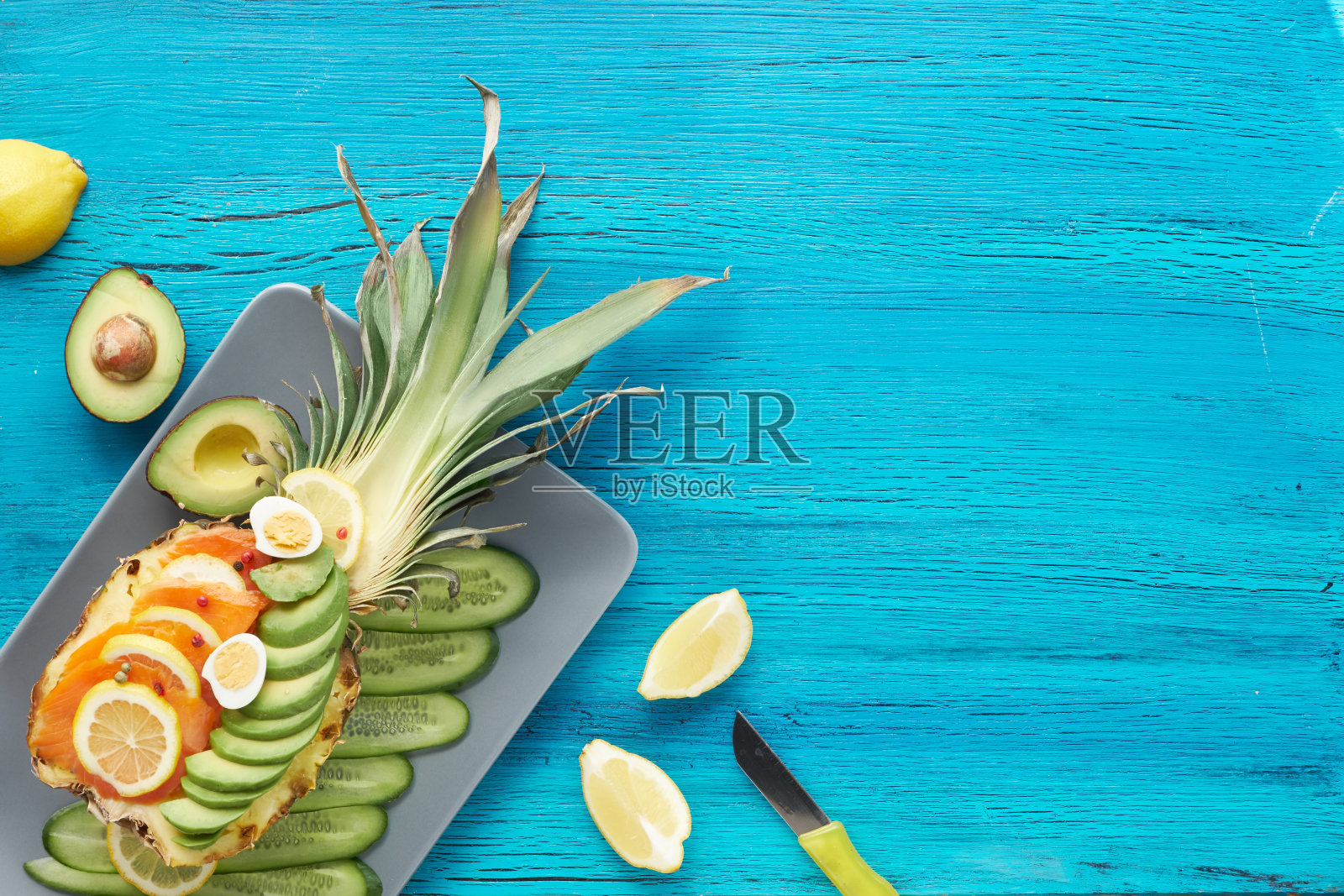 俯瞰菠萝船与烟熏鲑鱼，鳄梨，柠檬和鹌鹑蛋，复制空间照片摄影图片