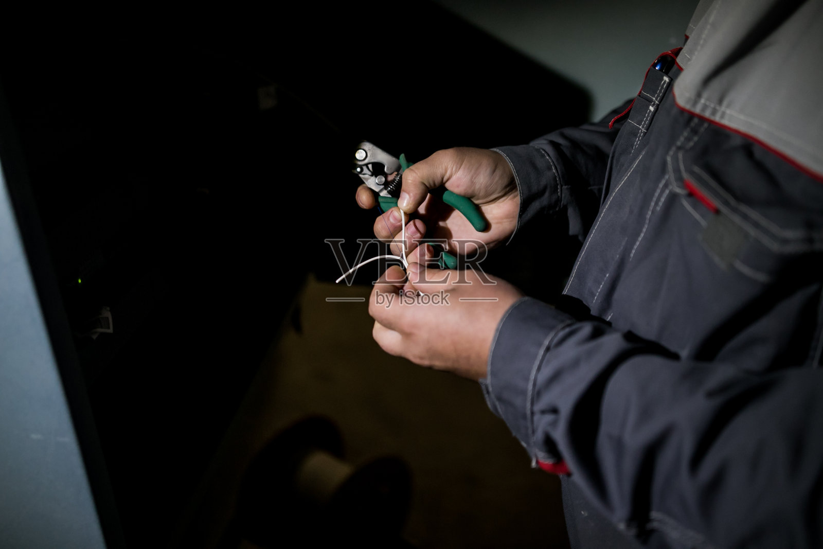 连接光纤到光配线架的技术人员。在网络服务器室工作的人，有用于数字通信和互联网的光纤集线器。照片摄影图片