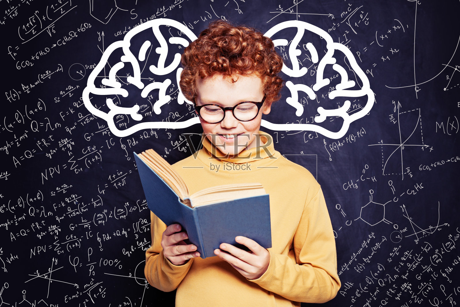 孩子拿着书在黑板背景上。可爱的小男孩，回到学校的概念照片摄影图片