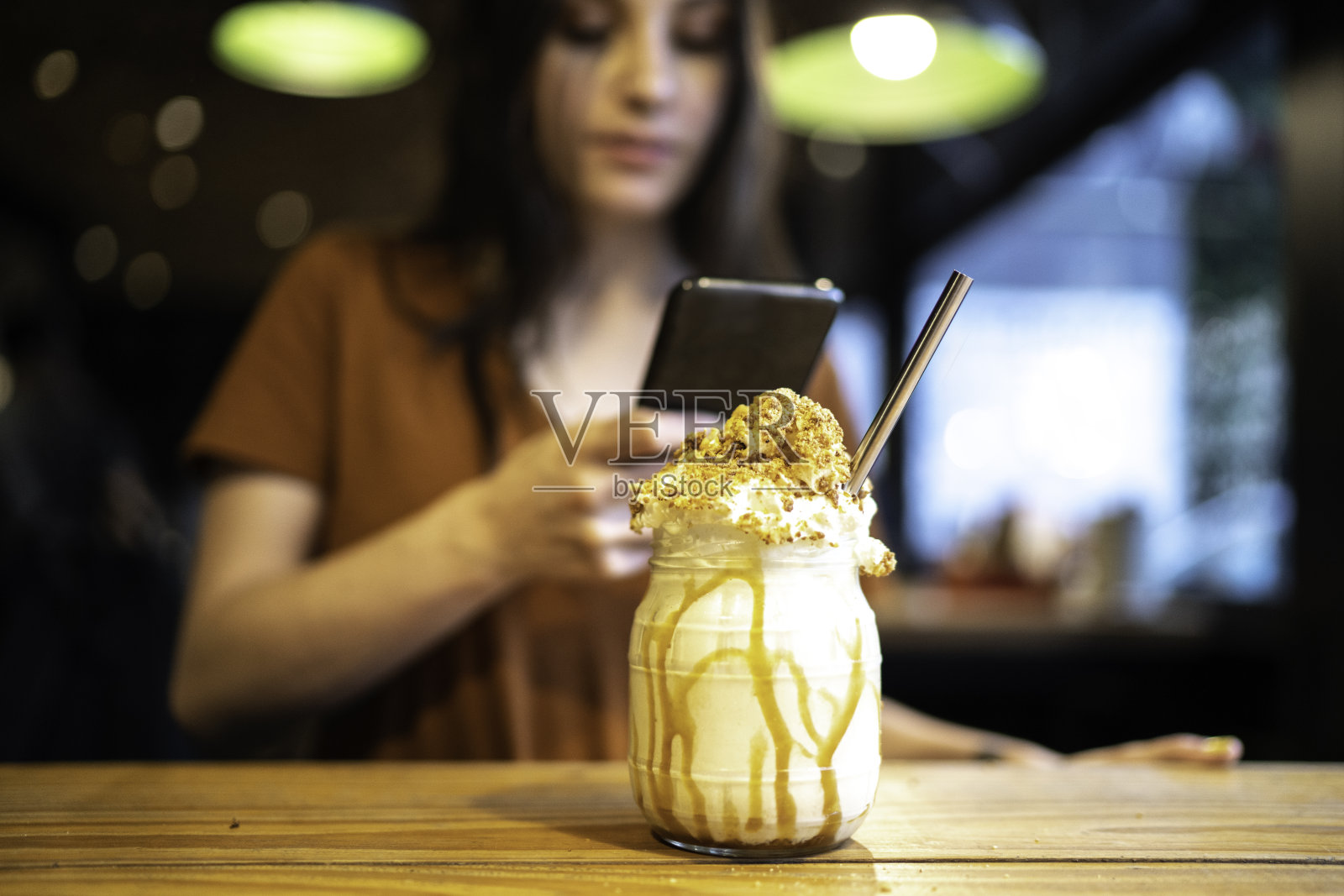 年轻女子在拍她的奶昔照片摄影图片