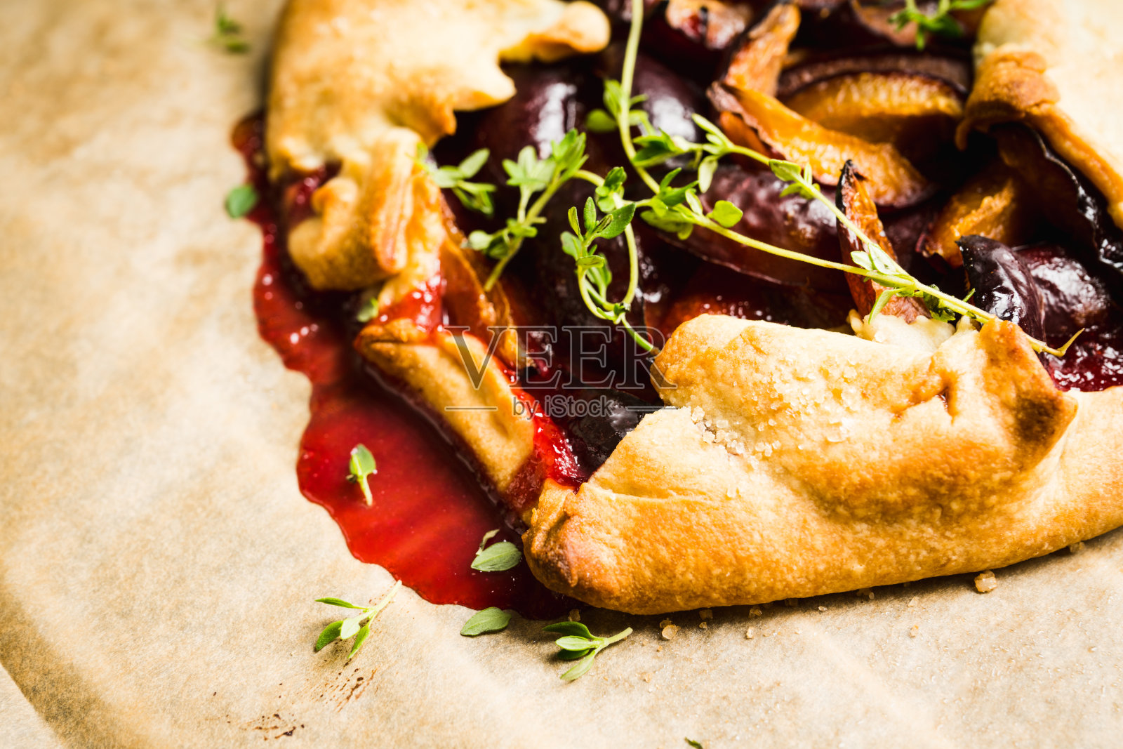 新鲜烤挞，李子和百里香在乡村背景照片摄影图片