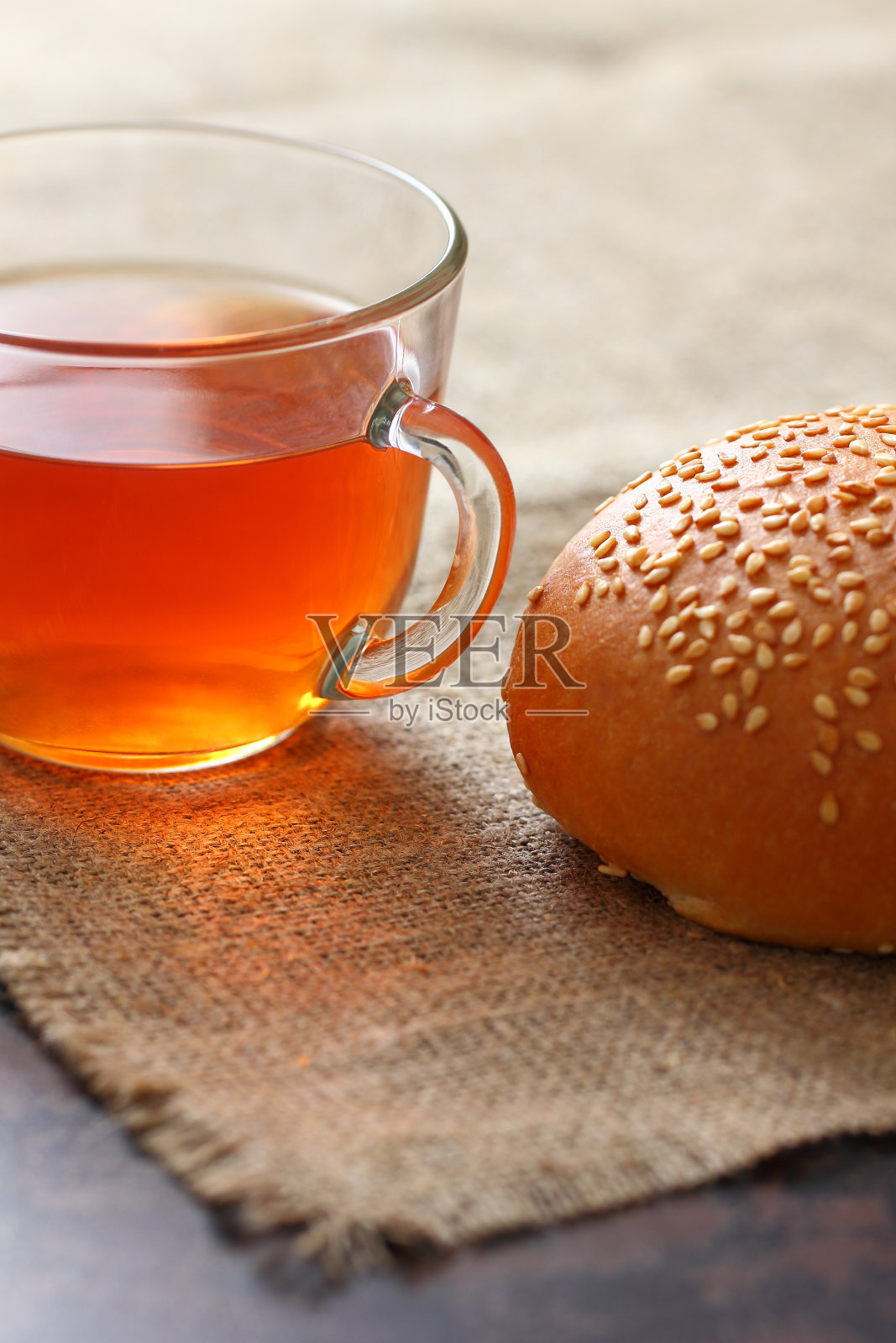 粗麻布桌布，芝麻面包，透明玻璃杯，红茶。照片摄影图片