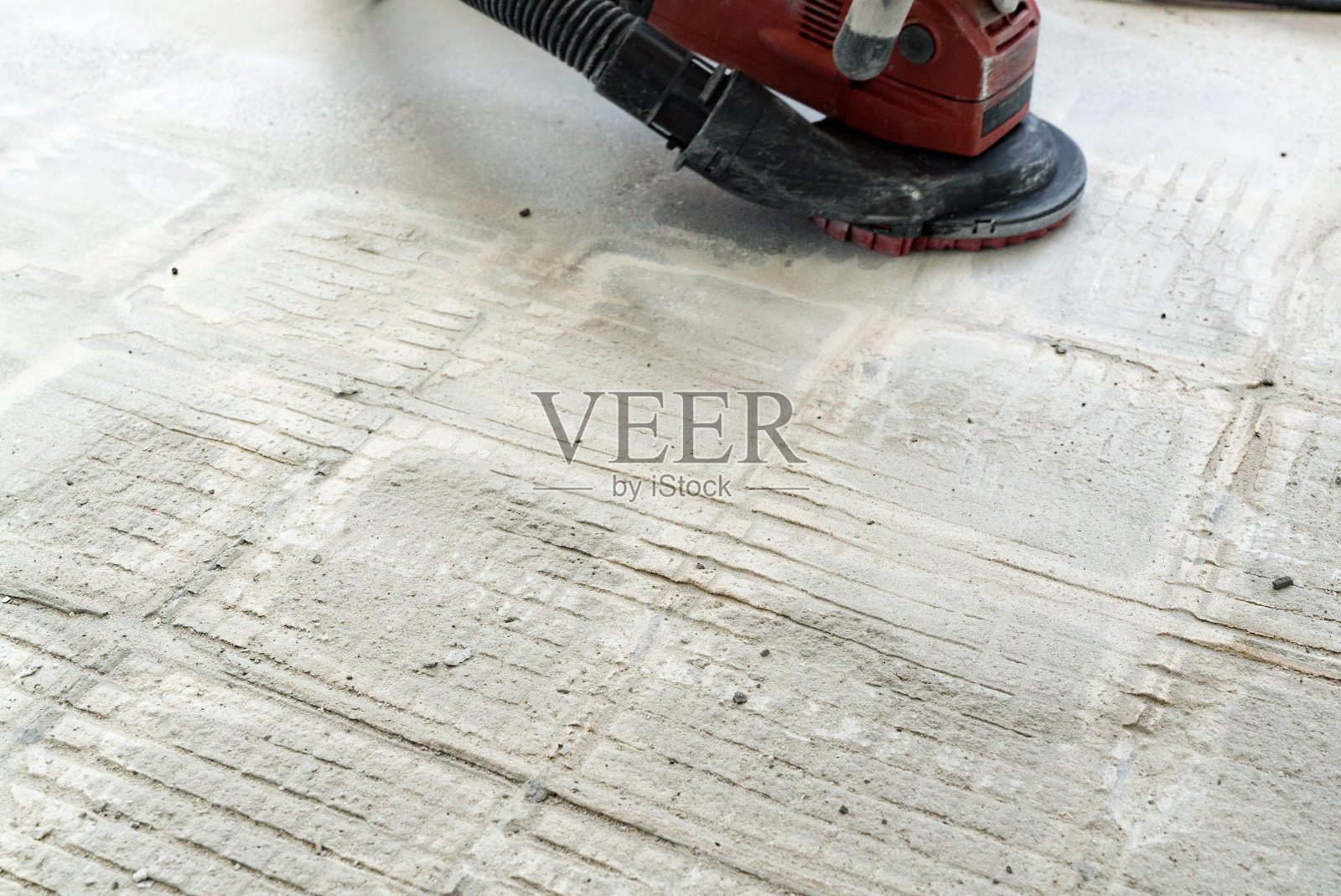 建筑工人在翻新工程中使用混凝土研磨机去除瓷砖胶水和树脂照片摄影图片