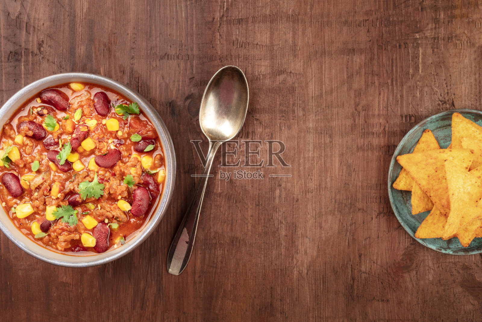 墨西哥食品设计模板。墨西哥辣味牛肉和玉米片，墨西哥玉米片，从上面拍摄在一个黑色的乡村木制背景与复制空间照片摄影图片