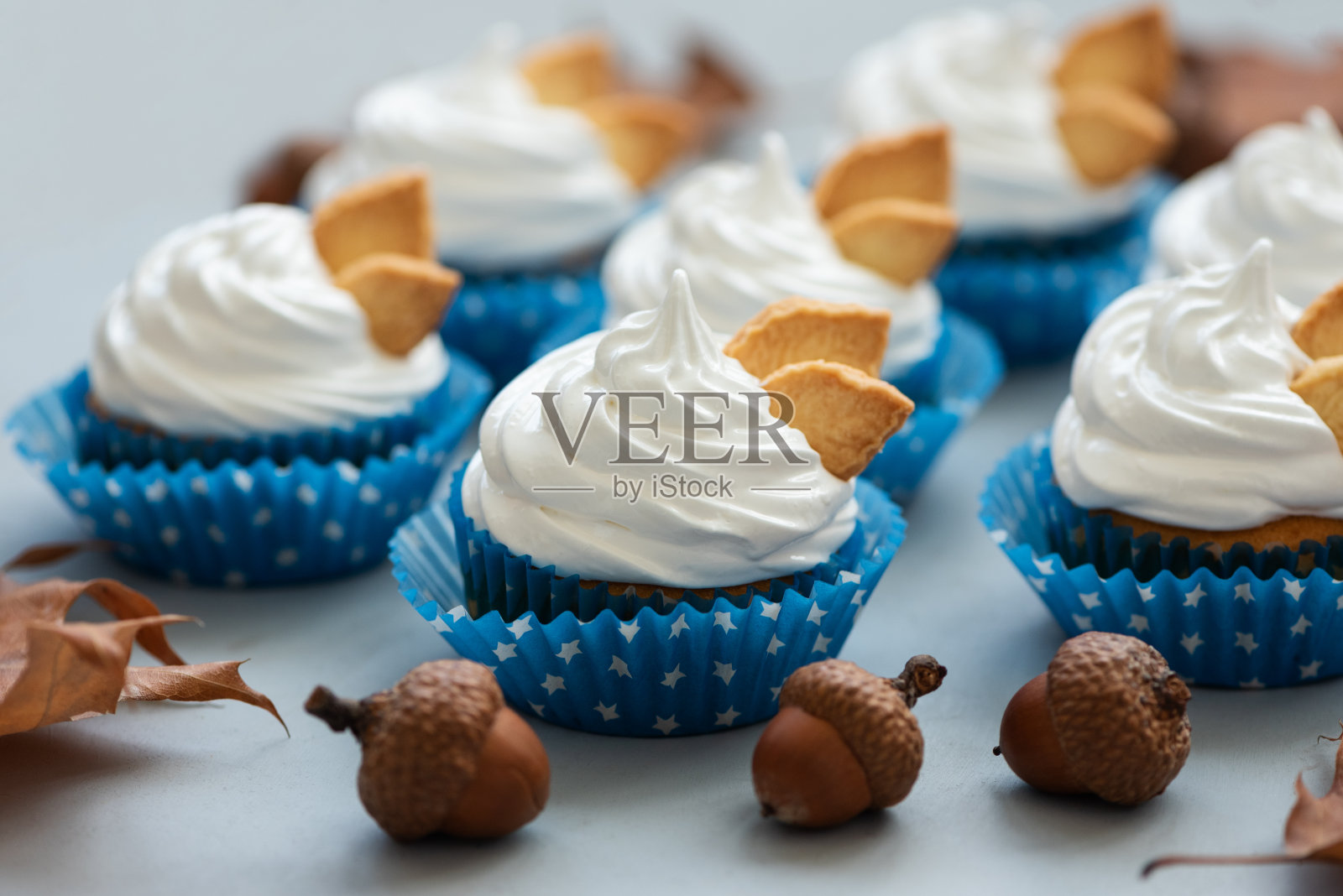 秋季纸杯蛋糕装饰奶油和饼干叶子在灰色的木制背景。软的焦点。感恩节或万圣节的庆祝概念照片摄影图片