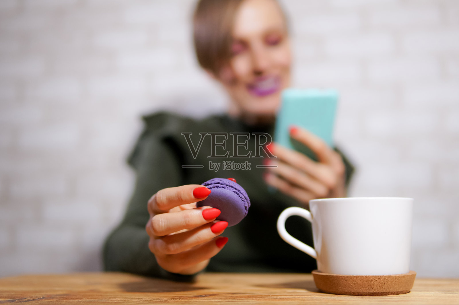 吃马卡龙。女性手拿马卡龙照片摄影图片