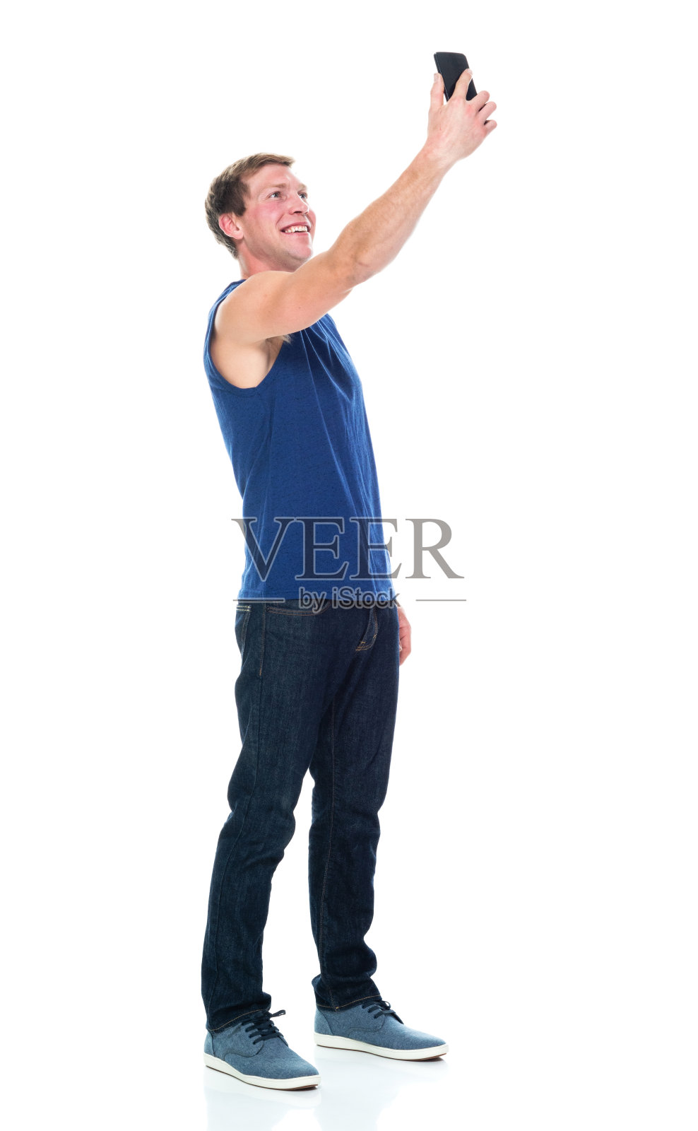 全身/侧视图/侧面视图/一人一男/ 20-29岁的成年人英俊的人白种人男性/年轻男子摄影/无袖站立穿着背心/牛仔裤/裤子/帆布鞋/酷的态度照片摄影图片