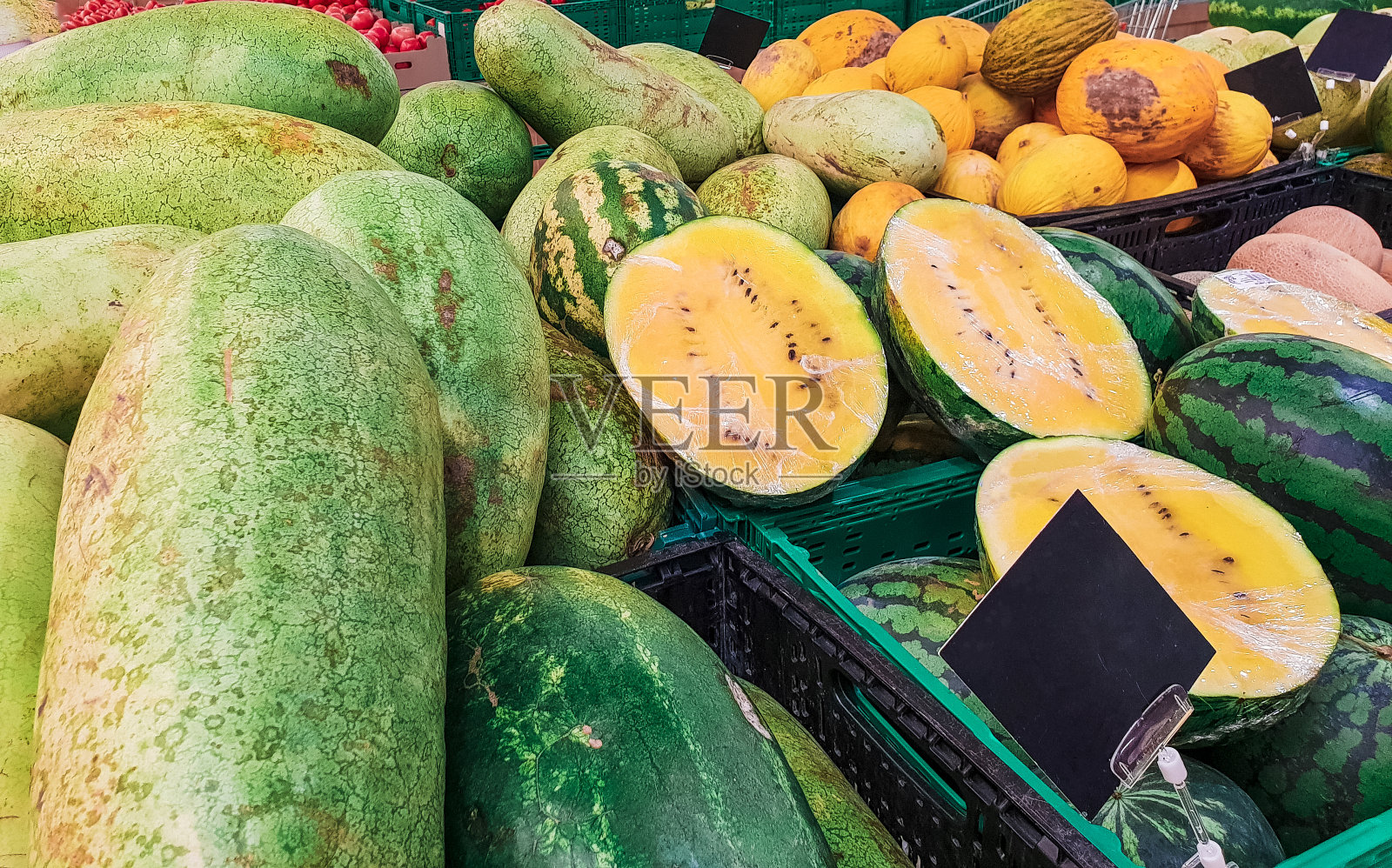 新鲜，甜，天然农场种植，黄色的热带有机水果切片与坚硬的绿色外皮，红色多汁的果肉和许多黑色的种子在自然界。街边小吃摊上的时令水果照片摄影图片