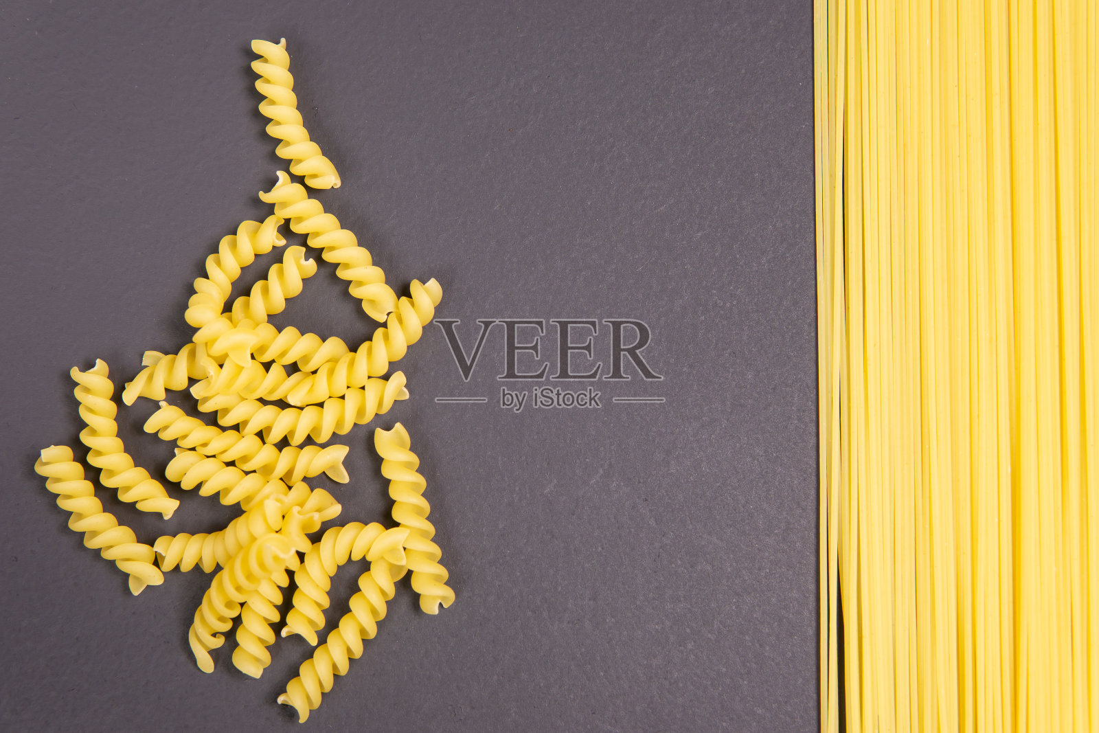 灰色背景上螺旋状的生意大利面照片摄影图片