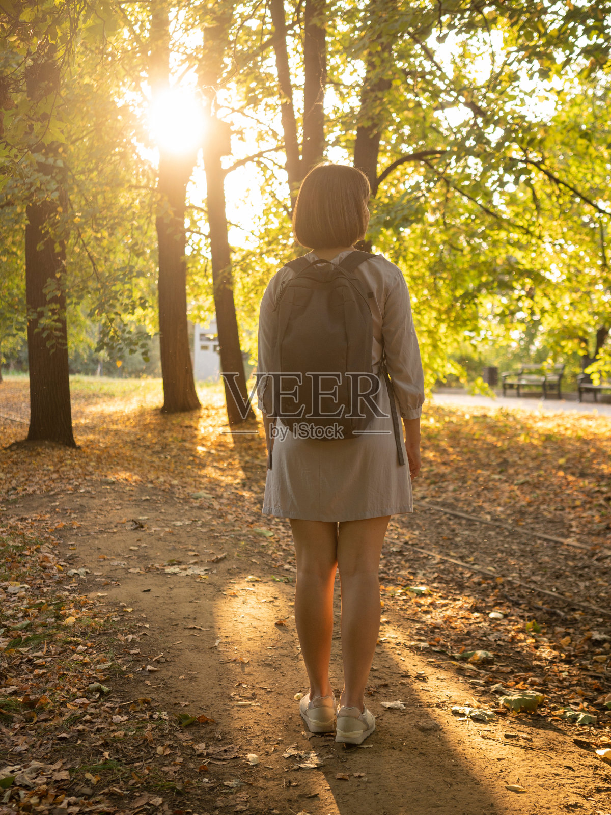 秋日里，一个女人独自走在公园里照片摄影图片