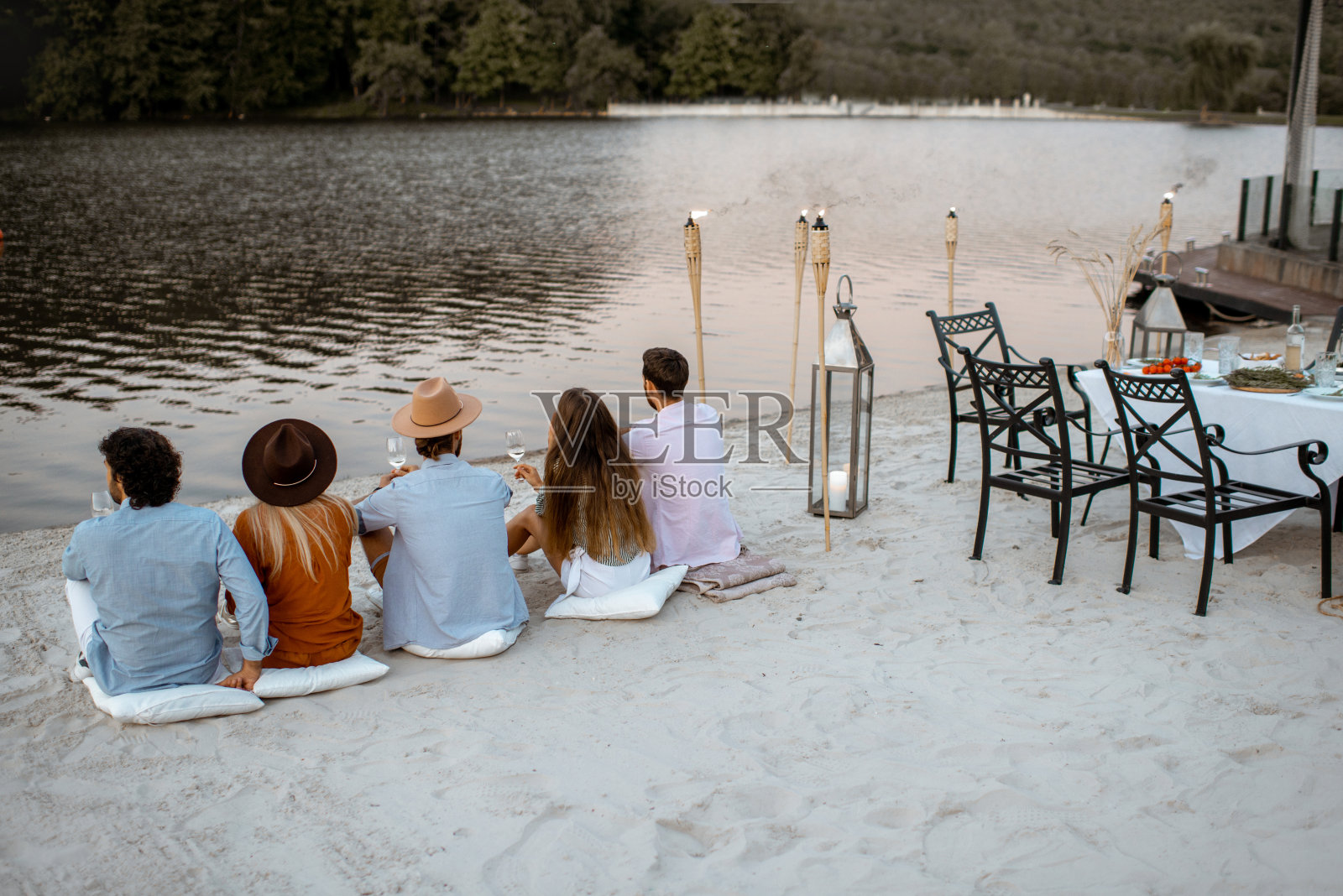 朋友们在海滩上享受节日晚餐照片摄影图片