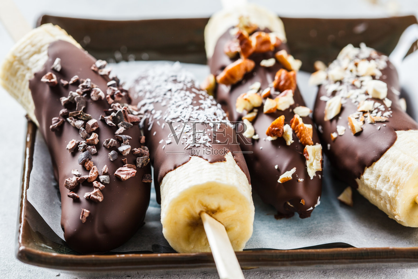 给孩子们的素食甜点。香蕉加坚果黑巧克力。照片摄影图片