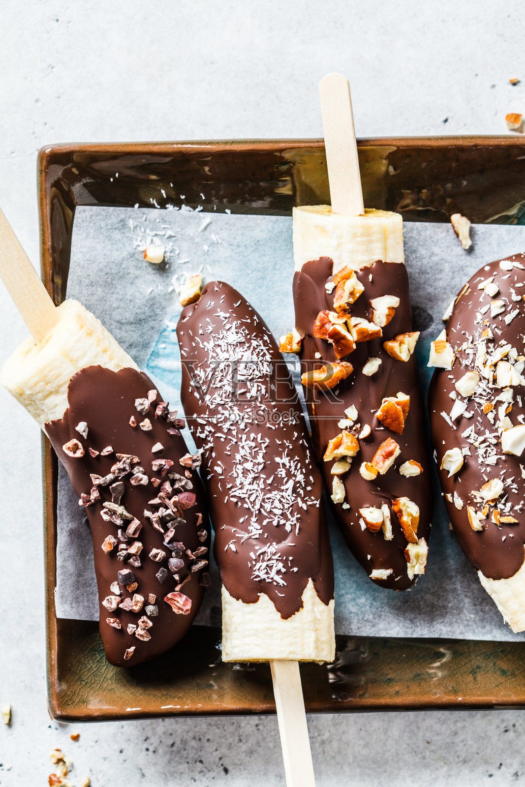 给孩子们的素食甜点。香蕉加坚果黑巧克力。照片摄影图片