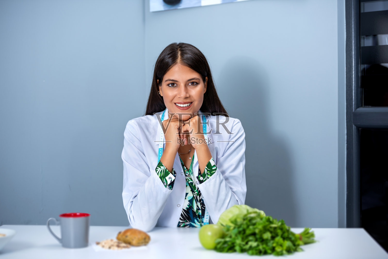 营养师在咨询中看着摄像机展示健康蔬菜照片摄影图片