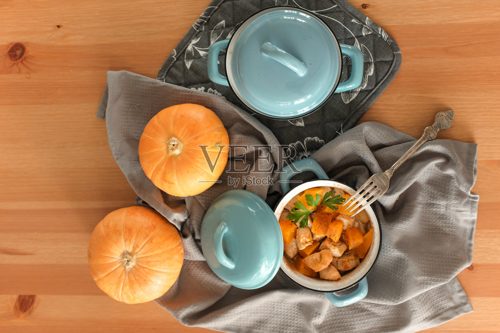 木桌上的蓝色平底锅里烤南瓜照片摄影图片