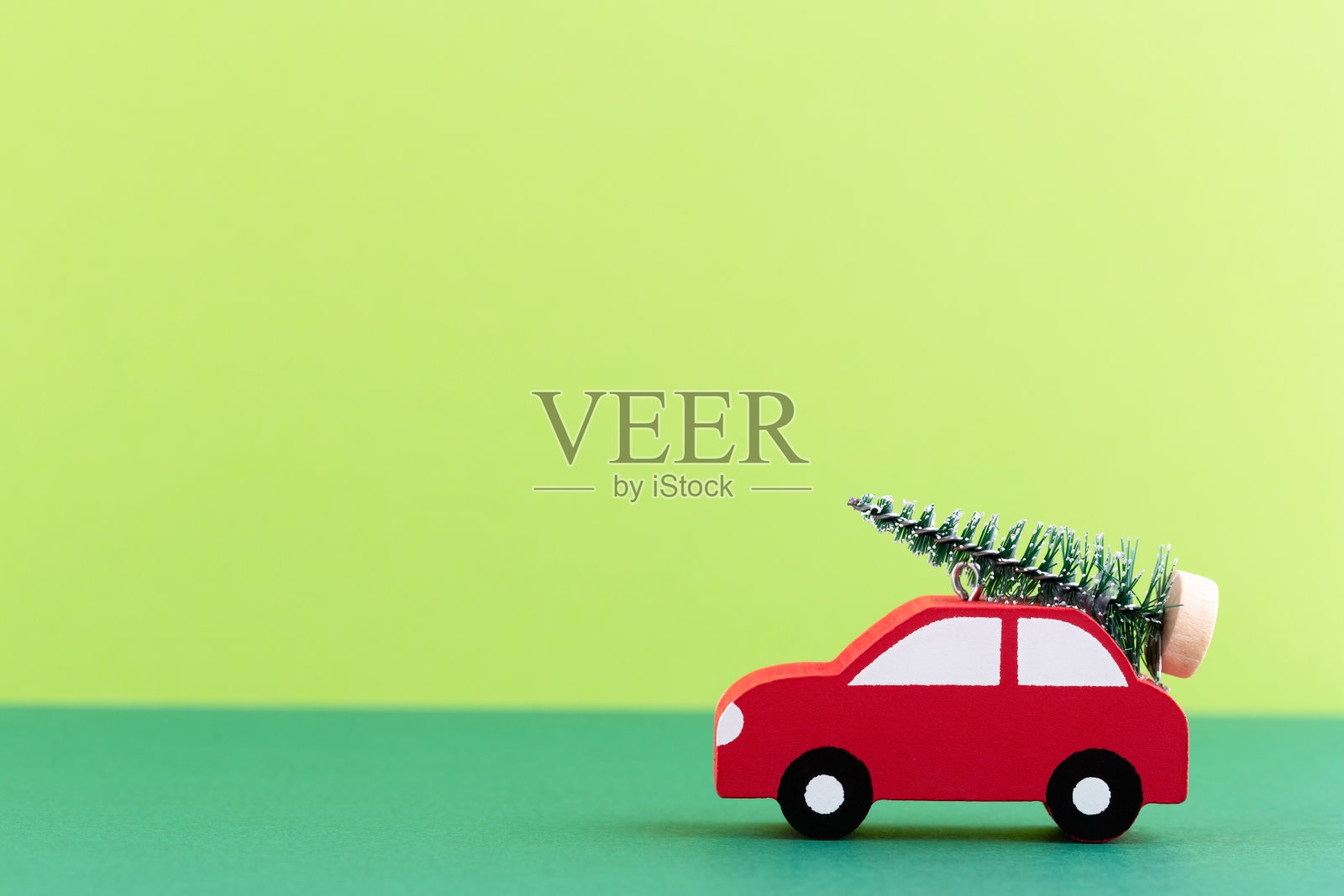 圣诞车在柔和的颜色背景。圣诞节或新年的最小概念。照片摄影图片