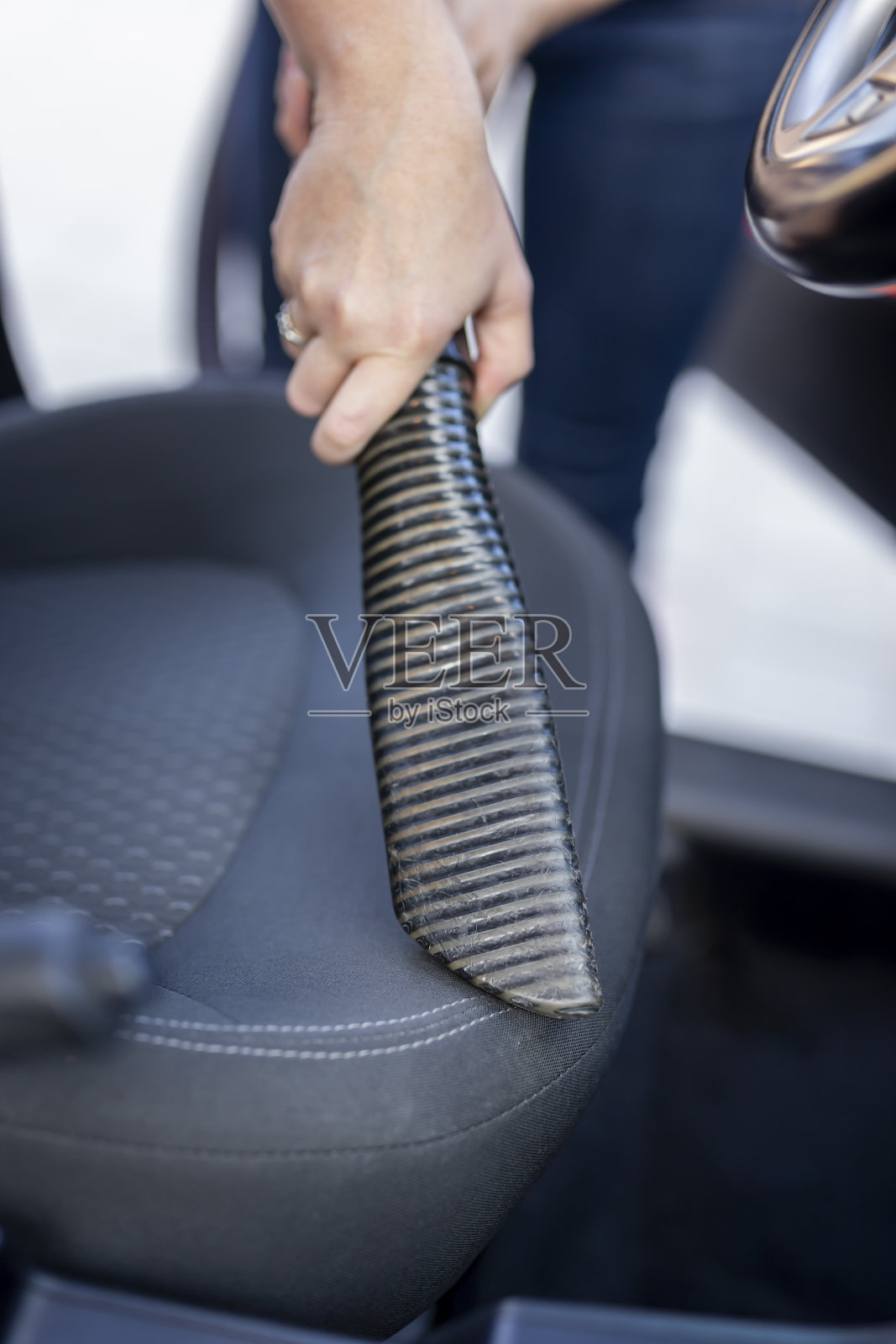 女人用吸尘器清洁汽车座椅照片摄影图片