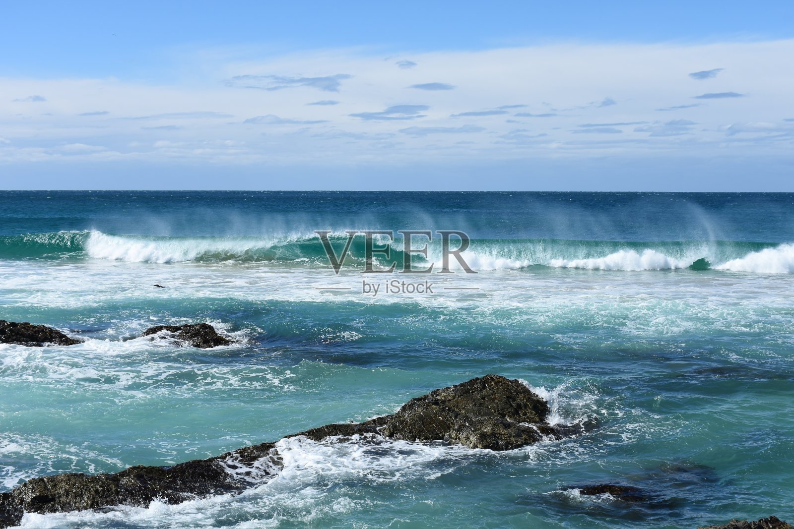 海浪冲击着淹没的岩石照片摄影图片