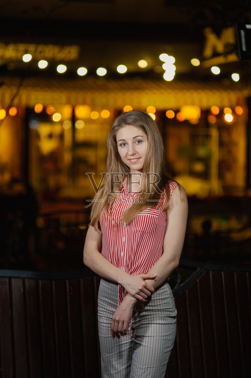 美丽快乐的女孩晚上在公园里提着燃烧的灯笼站着照片摄影图片