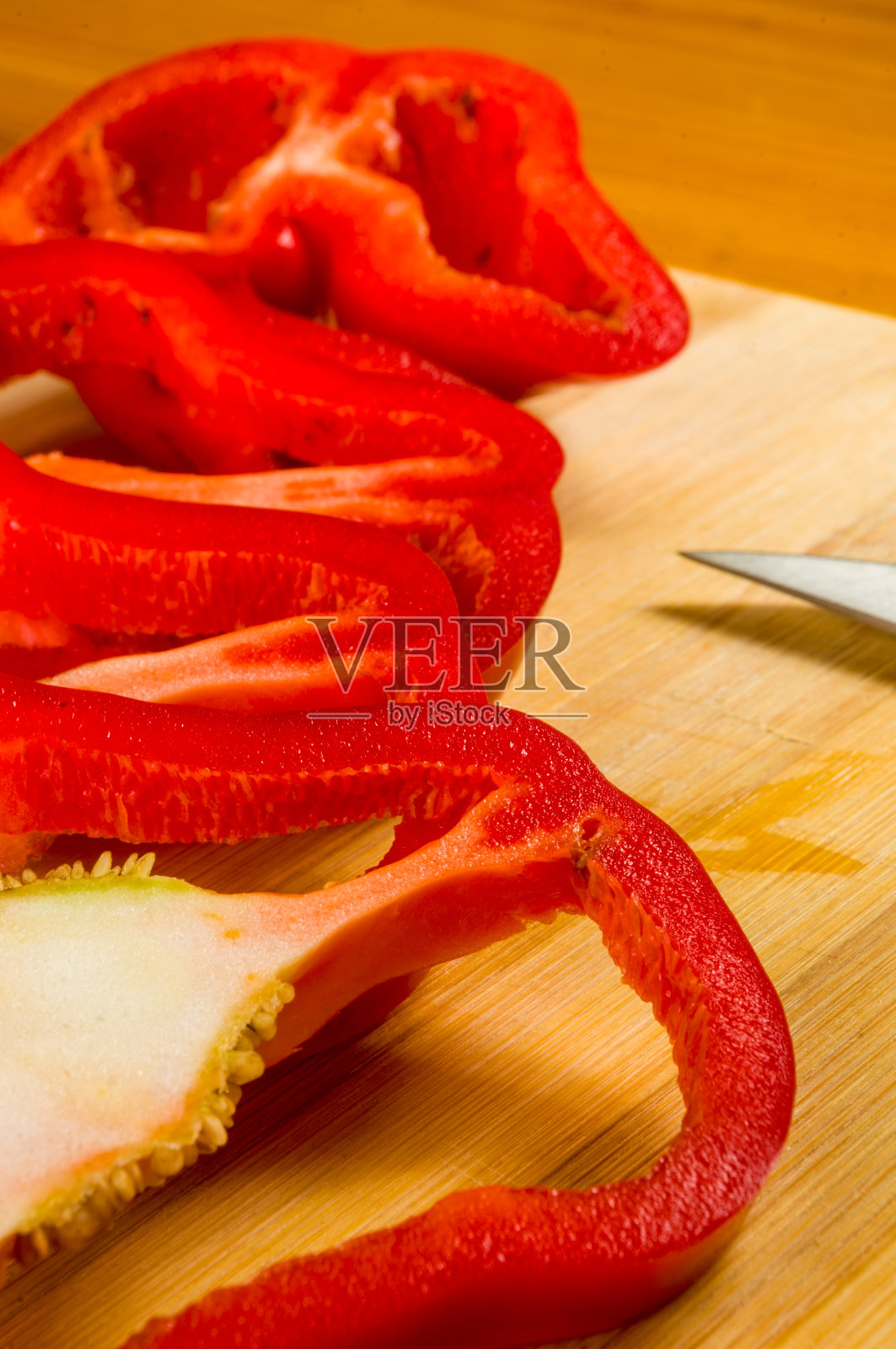鲜红辣椒、甜椒切片放在竹板上照片摄影图片