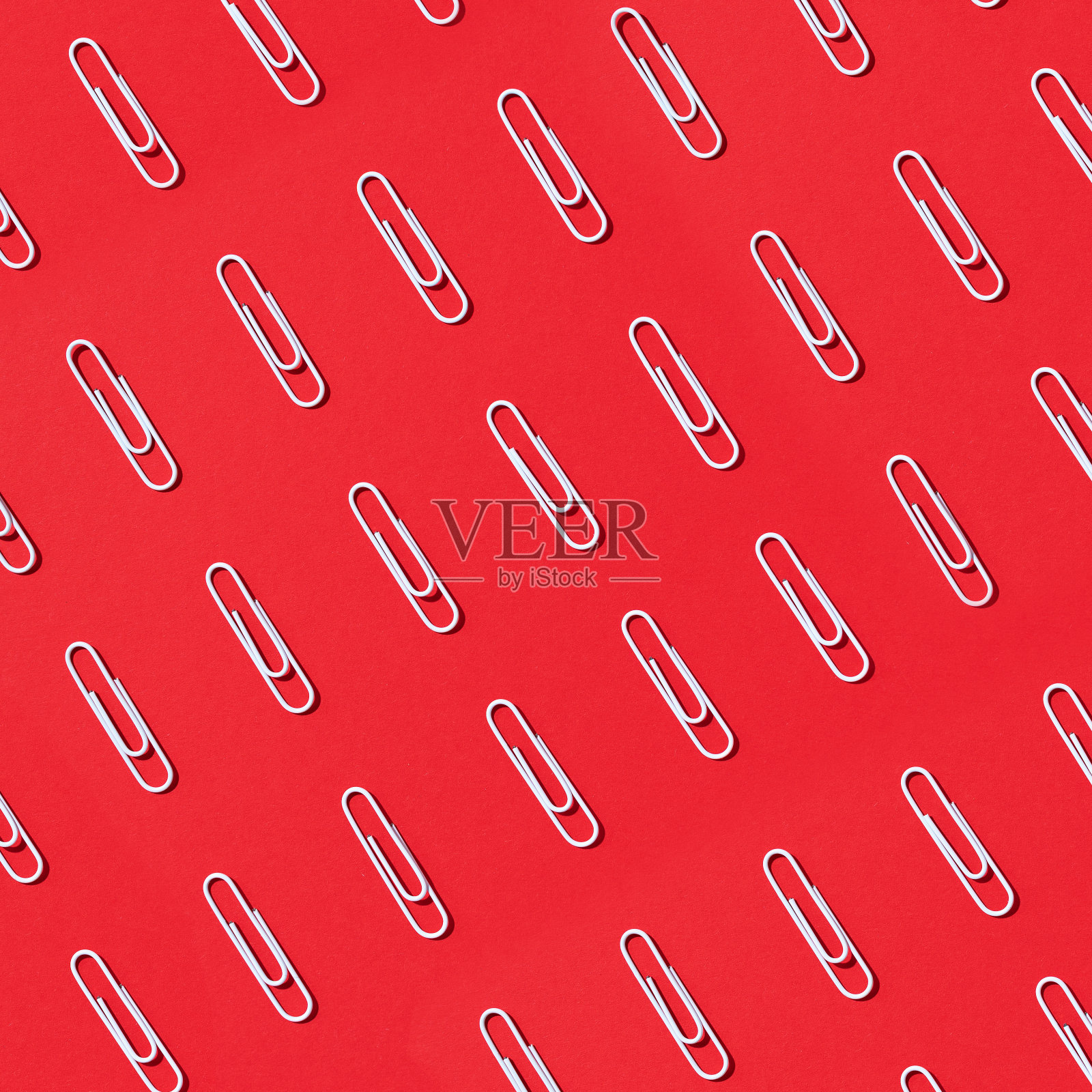 红色背景上的白色回形针图案。回到学校。办公、商务、文书、教育理念。横幅照片摄影图片
