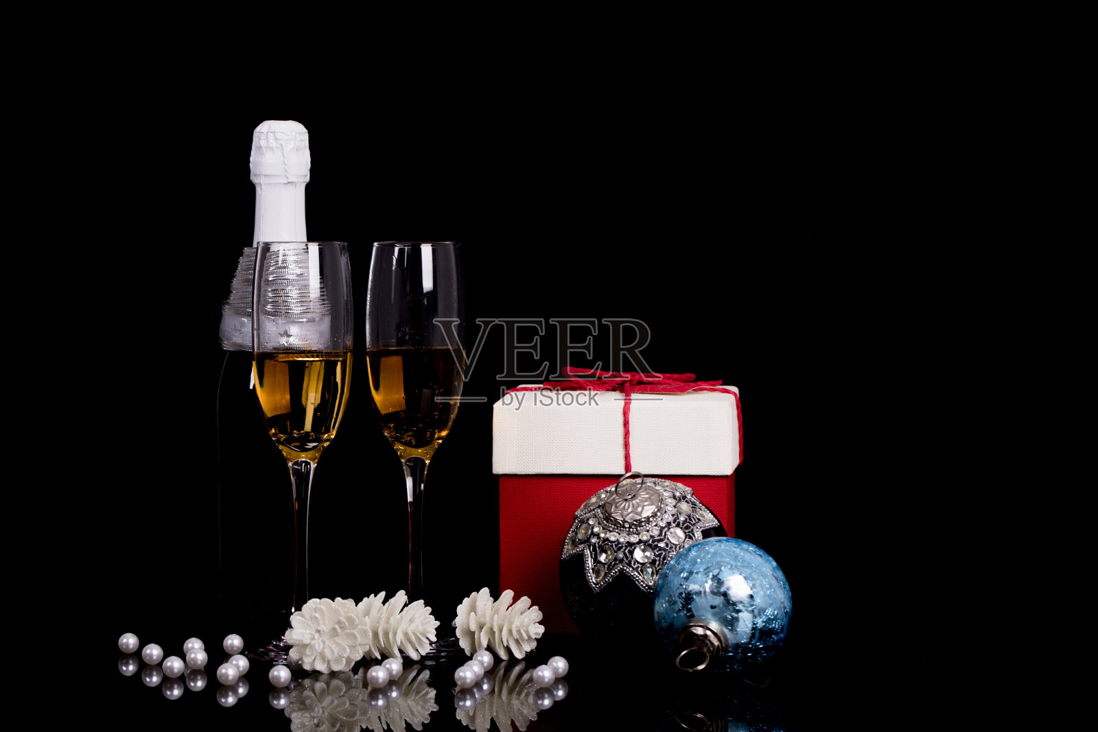 两个葡萄酒杯，香槟，礼盒和圣诞装饰品在一个黑色的背景照片摄影图片